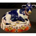 A Royal Crown Derby paperweight, Friesian Cow Buttercup, gold 21st Anniversary stopper, printed