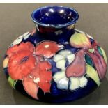 A Moorcroft Orchid pattern compressed ovoid vase, paper label to base, mid 20th century, 8cm high