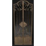 Interior Decoration - a large arched top rectangular wall mirror set behind a pair of metal gates,