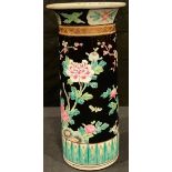 A Chinese cylindrical famille noire vase, enamelled with colourful pink and green blossom on a black
