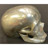 A cast metal model of a human skull, with articulated lower jaw, 9.5cm high