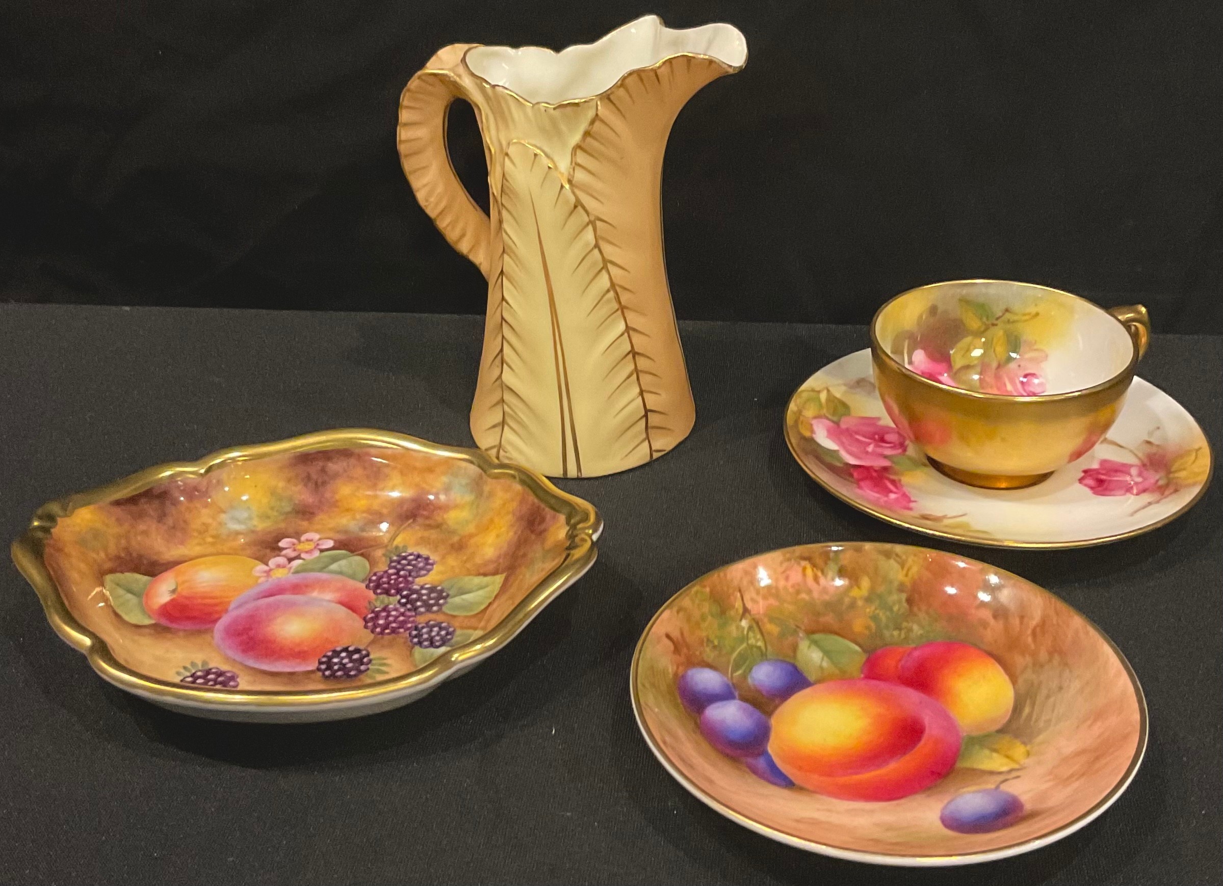 A Royal Worcester miniature teacup and saucer, painted with pink rosebuds, gilded exterior, dated