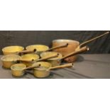 Kitchenalia - a set of seven graduated brass saucepans; a large copper saucepan (8)