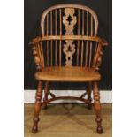 A 19th century Yorkshire yew and elm Windsor elbow chair, hoop back, shaped and pierced Christmas