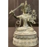 A large patinated bronzed metal model of Manjushri, 39cm high