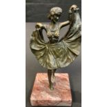 After Bergman, a bronzed figure of an exotic dancer, her skirt lifting to reveal a nude, marble