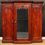 A Victorian mahogany breakfront wardrobe, outswept cornice above a central mirror door carved and