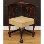 A George II Revival mahogany corner chair, curved cresting rail, the arms carved with scrolling