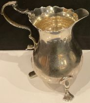 A Victorian baluster silver cream jug in George II style, shaped rim, acanthus capped scroll handle,