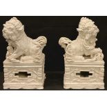 A pair of Chinese Blanc De Chine models, of Guardian Lions, pierced stands, 21cm high