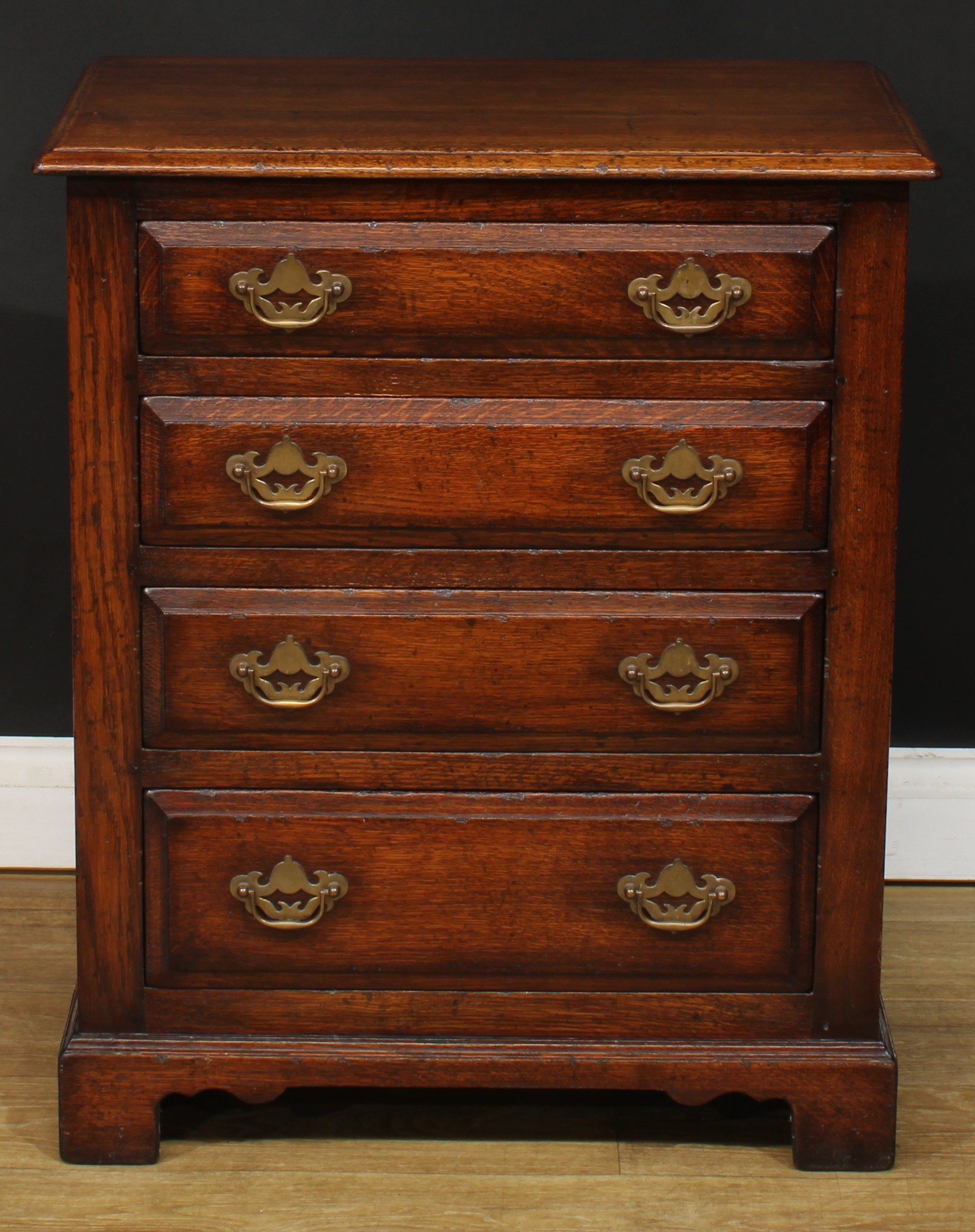 An oak chest of four long drawers, of small and neat proportions, by Titchmarsh & Goodwin, badged,