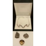 Jewellery - an Edwardian silver locket, mounted with a lion; a silver circular locket; heart locket;