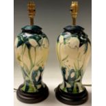 A pair of Moorcroft Snowdrop pattern inverted baluster table lamps, tube lined with slender leafy