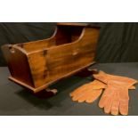 A pair of brown leather flying gloves; a stained pine doll's cradle
