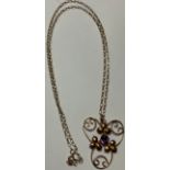 An Edwardian 9ct rose gold pendant, set with a single faceted amethyst within leafy scroll supports,