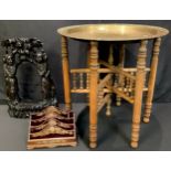 An early 20th century brass table top, collapsible stand, 50cm diam; a padauk wood bell stand,