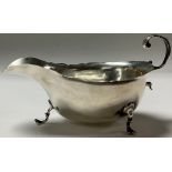 An Edwardian silver sauce boat in George III style, acanthus capped flying s-scroll handle,