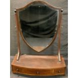 A George III revival mahogany dressing mirror, shield shaped bevelled glass, sloping reeded supports