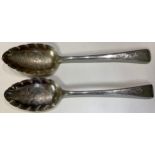 A composed pair of silver GIII Old English pattern berry spoons, engraved and chased with foliate
