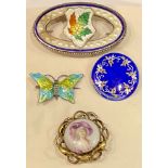A silver and enamel maple leaf brooch, marked Sterling; two enamel brooches; a porcelain brooch (4)