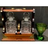 A mahogany two bottle tantalus, cut glass decanters, seprated by a pack of playing cards, 28cm high;