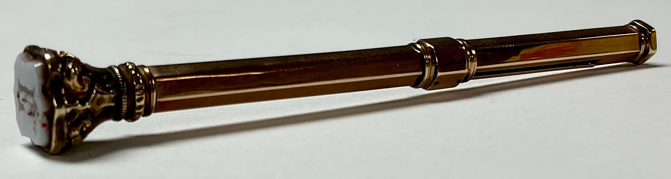 An early 20th century yellow metal propelling pencil, stone set finial, 9.4g gross