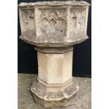 A 19th century carved stone and composition octagonal church font, carved with a gothic style