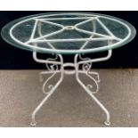 A circular patio table, glass top, scroll base, 100cm diam, 73cm high **Please note that some of the