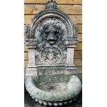 A 19th century marble lion head wall fountain, the arched back carved with lion and acanthus
