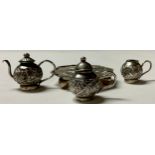 A Chinese silver miniature three piece tea service on tray, chased with leafy bamboo,the octagonal