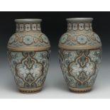 A pair of Doulton Lambeth Silicon vases, incised with and in relief with flowers, and scrolls, in