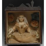 A 19th century wax doll diorama, finely dressed and set amongst flowers, stained pine case, 38cm