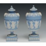 A pair of 19th century Wedgwood Jasperware pedestal vases and covers, typically sprigged in white