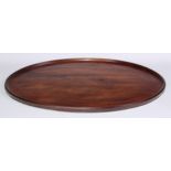 A George III mahogany oval serving tray, of one piece construction, dished border, 61cm wide, c.1765