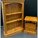 A pine three tier open bookcase, 132cm high, 85cm wide, 26cm deep; a pine bedside chest, open