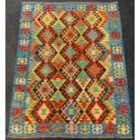 An Anatolian Kilim rug / carpet, woven with geometrical motifs in shades of red, ochre, turquoise