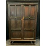 A Jacobean revival oak wardrobe on stand, 197cm tall x 127cm wide x 48cm deep.