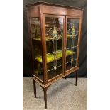An Edwardian mahogany china cabinet, pair of glazed stained-glass doors enclosing two tiers of
