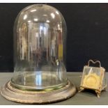 A glass dome, ebonised stand, 30cm high; a Palais Royale watch case, 11cm high