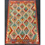 An Anatolian Kilim rug / carpet, woven with an arrangement of diamonds within a field of red,