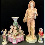 A German figural base, set with three scantilly clad cherubs with floral garlands, shaped base, 26cm