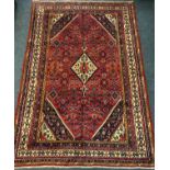 A Persian Hamadan rug / carpet, the central diamond-shaped medallion within a densely woven field of