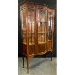 An Edwardian mahogany bow-front display cabinet, the central bow-front astral-glazed door flanked by