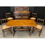 An Ercol dark elm dining room suite, comprising trestle dining table, four chairs, two carver