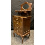 An early 20th century walnut mirror-top side cabinet, oval mirror, beveled glass, four drawers,