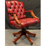 A contemporary Gainsborough type desk chair, button back and seat, ox-blood leather, rise-fall and