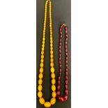 A Cherry amber coloured graduated bead necklace, from 25mm x 17mm ton , 13mm x 7mm, 35.4g, 58cm