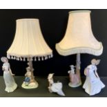 A pair of Nao figural lamps lamp, the bases with a girl and boy, printed mark; other figures
