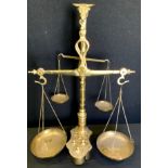 A set of brass apothecary/counter balance scales, bulls head capital, suspended pan dishes,