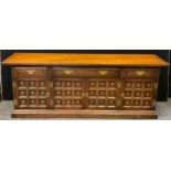 A 20th century oak sideboard, over-sailing rectangular top, above a row of two short and one long